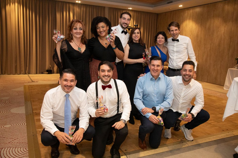 Eine Gruppe von Mitarbeitern lässt sich auf der Tanzfläche der Weihnachtsfeier der PlattesGroup fotografieren