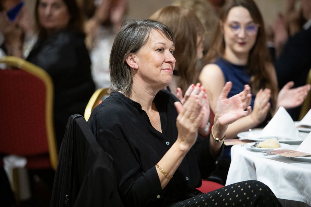 Gabriele Janisch, Sachbearbeiterin der PlattesGroup, klatscht Beifall auf der Weihnachtsfeier des Unternehmens