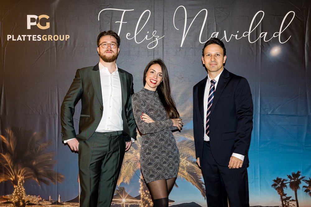 David Nadrowski, Barbara Diaz Arroyo, Gabriel Angel Estarellas Saletas zusammen vor der weihnachtlichen Fotowand.