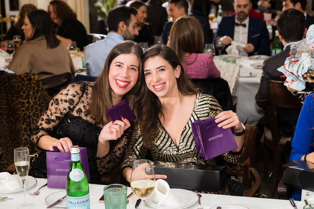 Zwei Arbeitskolleginnen posieren mit Weihnachtsgeschenken 