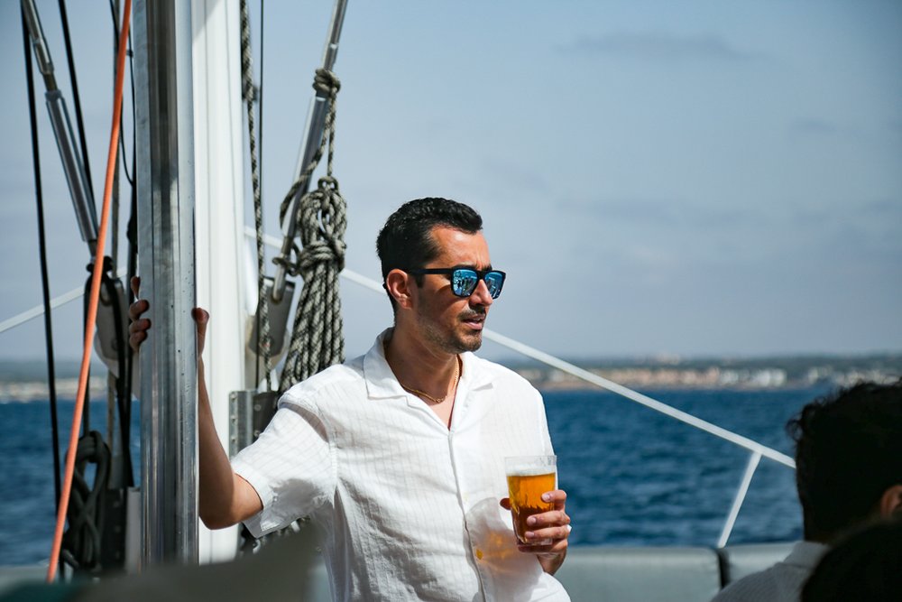 Team PlattesGroup an Board des Katamarans in der Sonne.