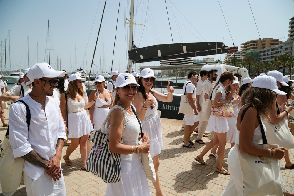 Das Team der PlattesGroup, vollständig in weiß gekleidet, auf dem Weg zum Katamaran.