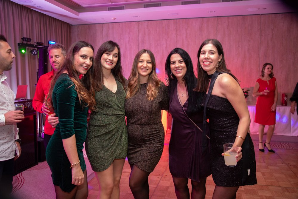 Eine Gruppe von Buchhalterinnen der PlattesGroup lässt sich auf der Tanzfläche der Weihnachtsfeier fotografieren